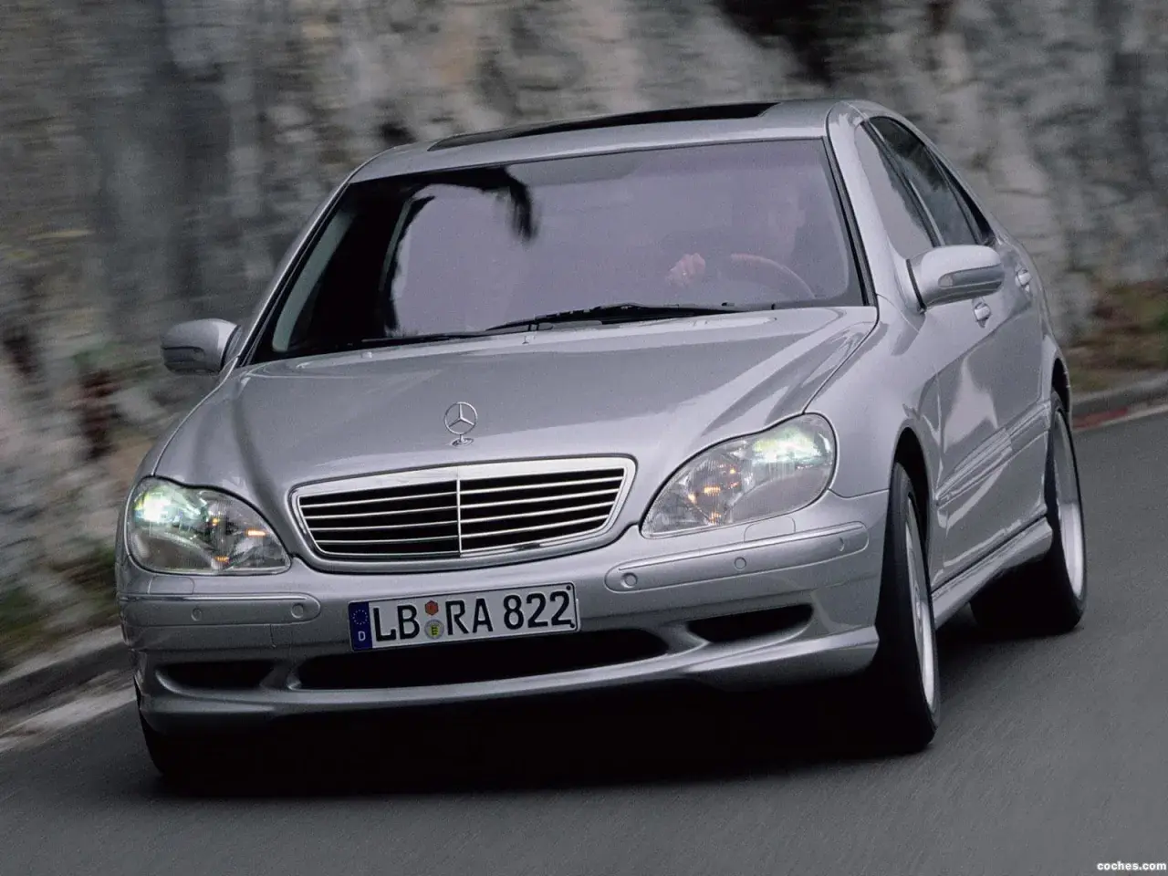 Mercedes plateado en movimiento, con el conductor visible. El sistema Airmatic parece funcionar perfectamente.