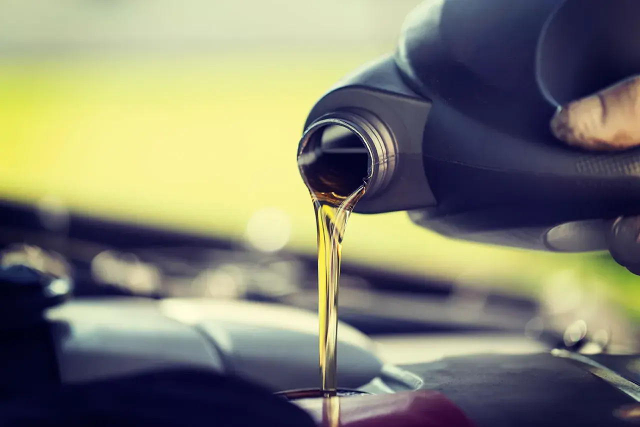 Vertiendo aceite de coche nuevo, ya que el aceite de coche caduca y necesita ser reemplazado para el buen funcionamiento del motor.
