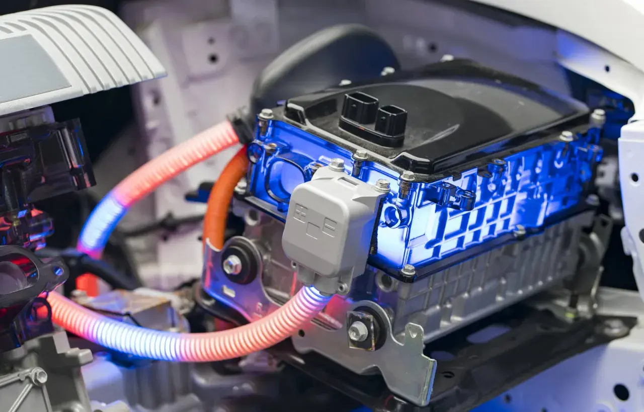 Componentes de un coche híbrido, con luces azules y naranjas. Responde a la pregunta de cuanto duran las baterias de un coche hibrido.