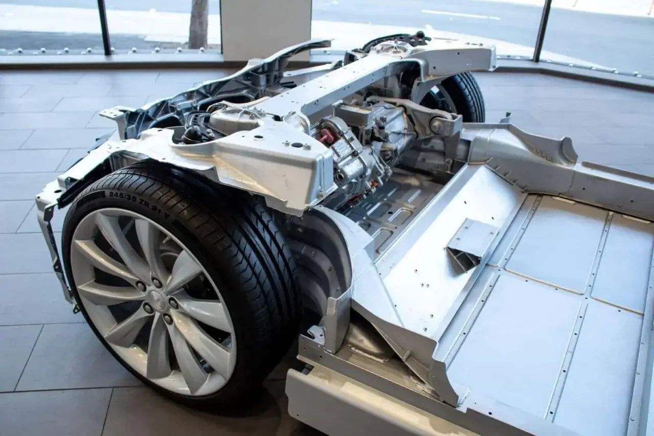 Chasis de coche el&eacute;ctrico expuesto, mostrando la bater&iacute;a y el motor. Ideal para entender el mantenimiento de un coche el&eacute;ctrico.