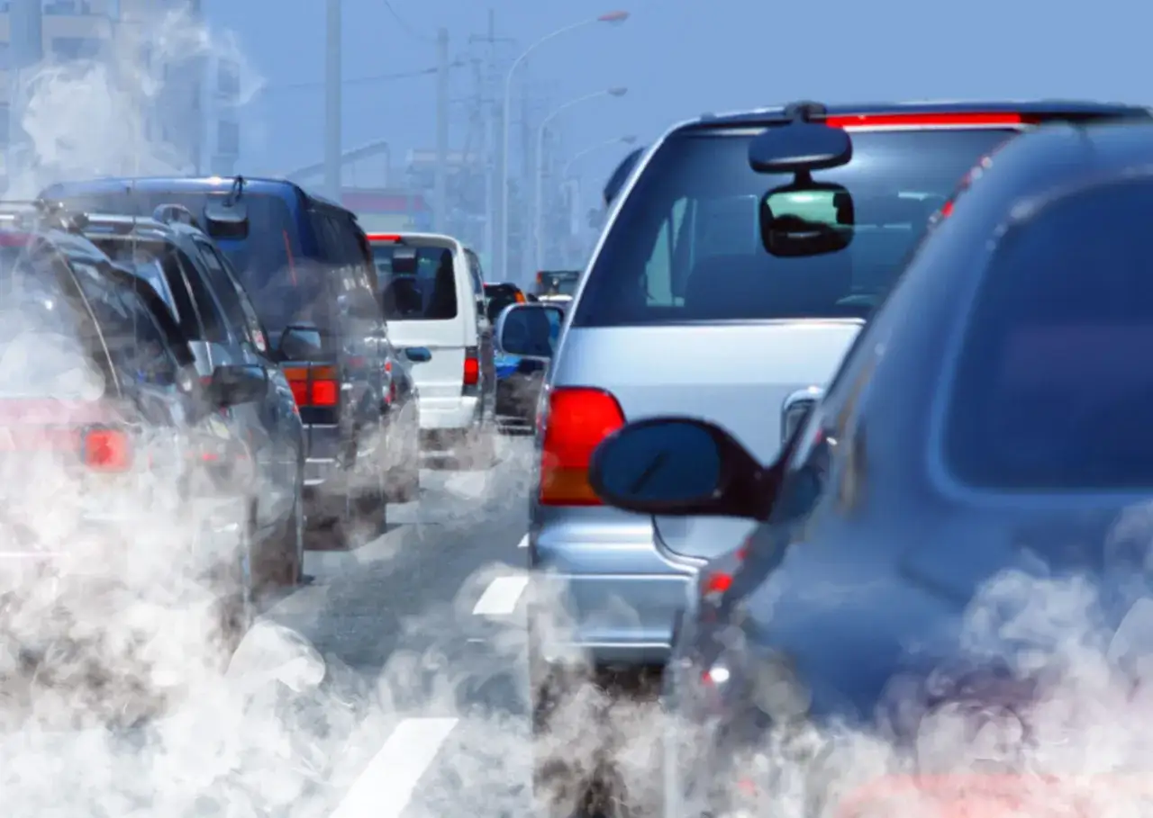 Tr&aacute;fico denso con humo saliendo de los coches. Una gu&iacute;a sobre como bajar el CO de un coche de gasolina.