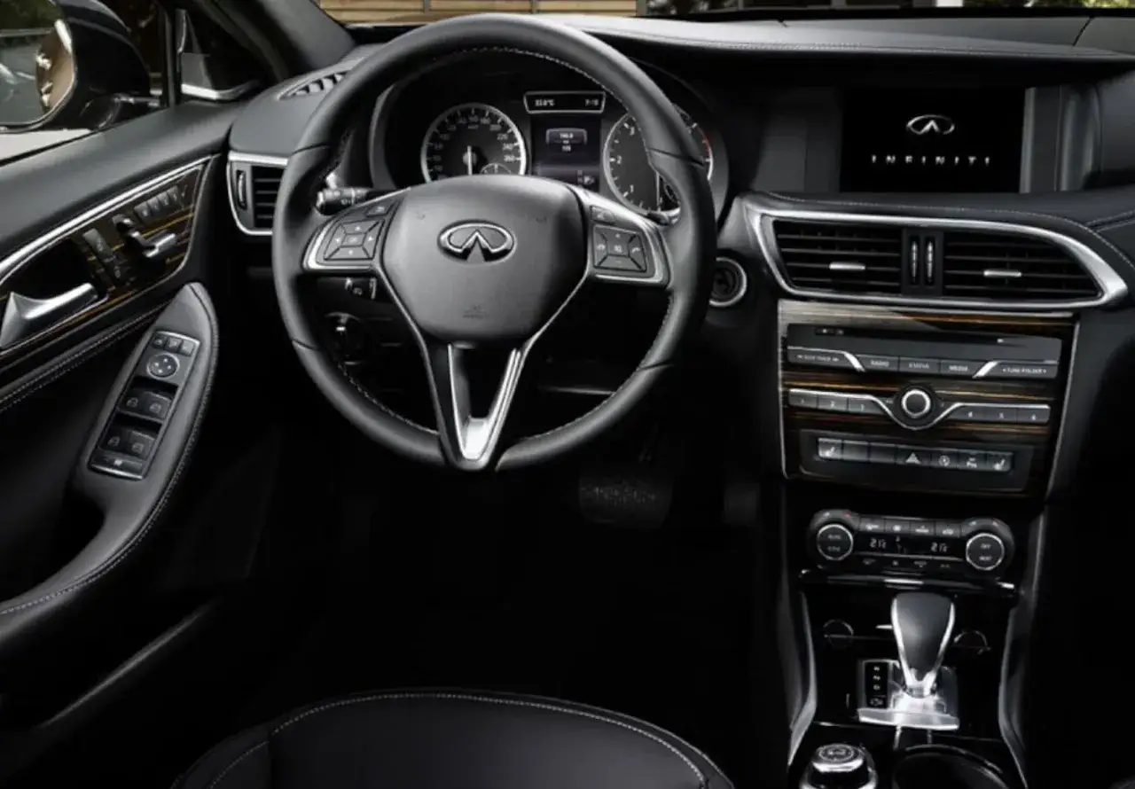 Interior de un Infiniti QX30, con volante, pantalla y consola central. Esperemos que no tenga problemas.