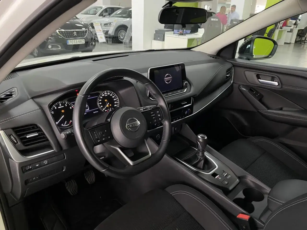 Interior de un Nissan Qashqai. El volante, salpicadero y pantalla central se ven. El motor Nissan Qashqai 1.3 140 CV ofrece buenas opiniones.