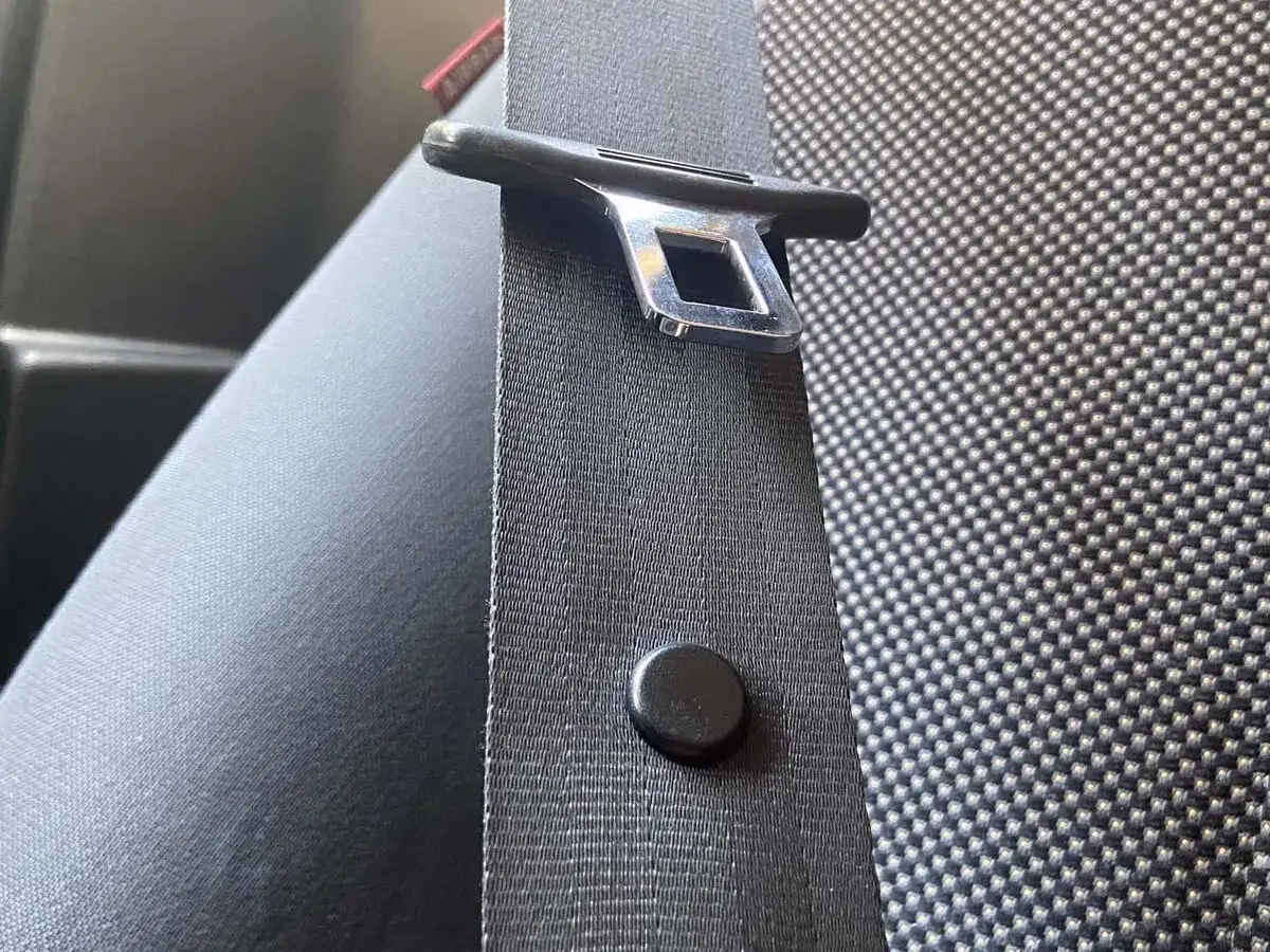 El bot&oacute;n del cintur&oacute;n de seguridad es clave para que el sistema funcione. Aqu&iacute; se ve el enganche met&aacute;lico y la cinta, listos para asegurar tu viaje.