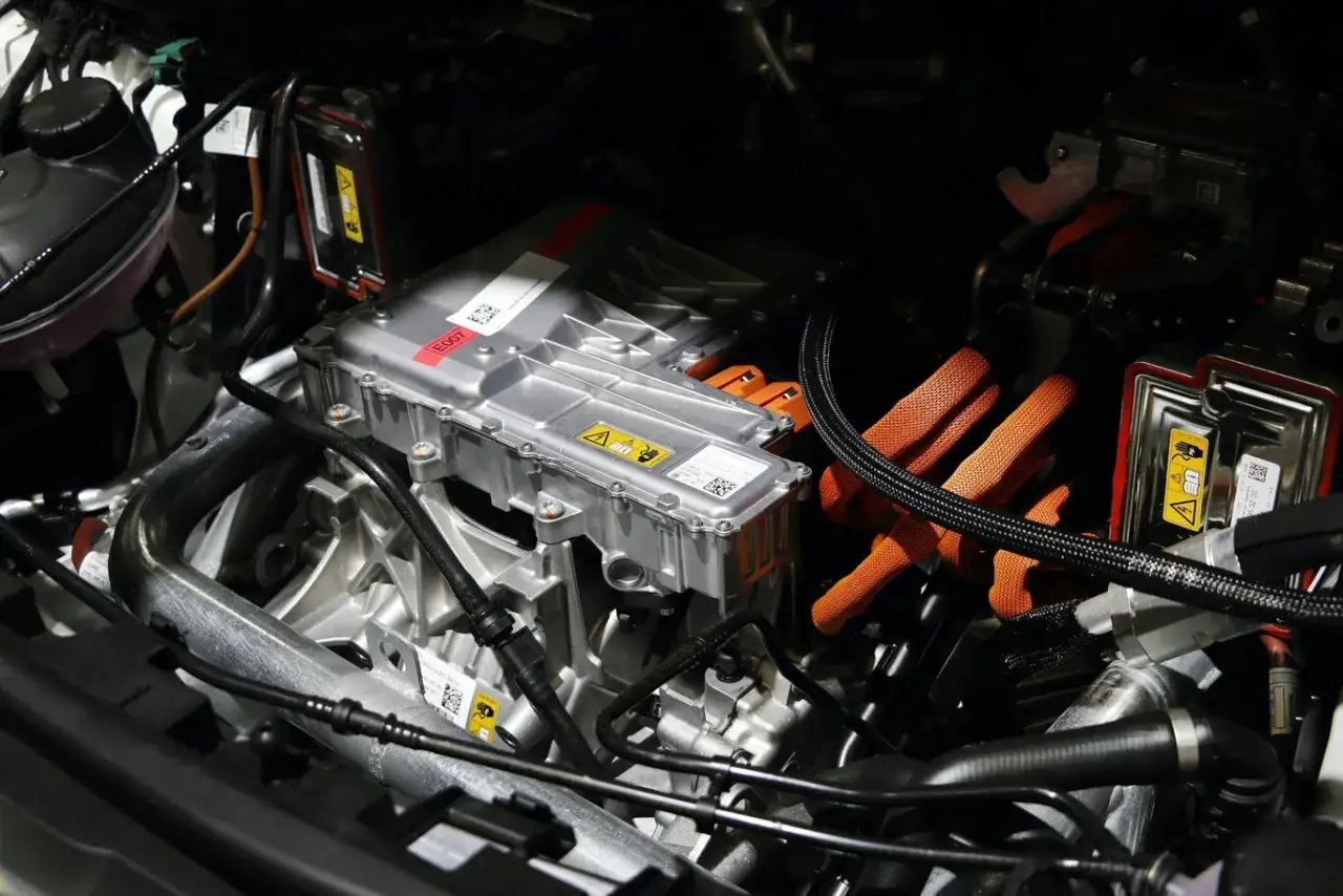 Componentes de la mec&aacute;nica de coches el&eacute;ctricos: unidad de potencia plateada, cables naranjas de alta tensi&oacute;n y sistemas de refrigeraci&oacute;n.