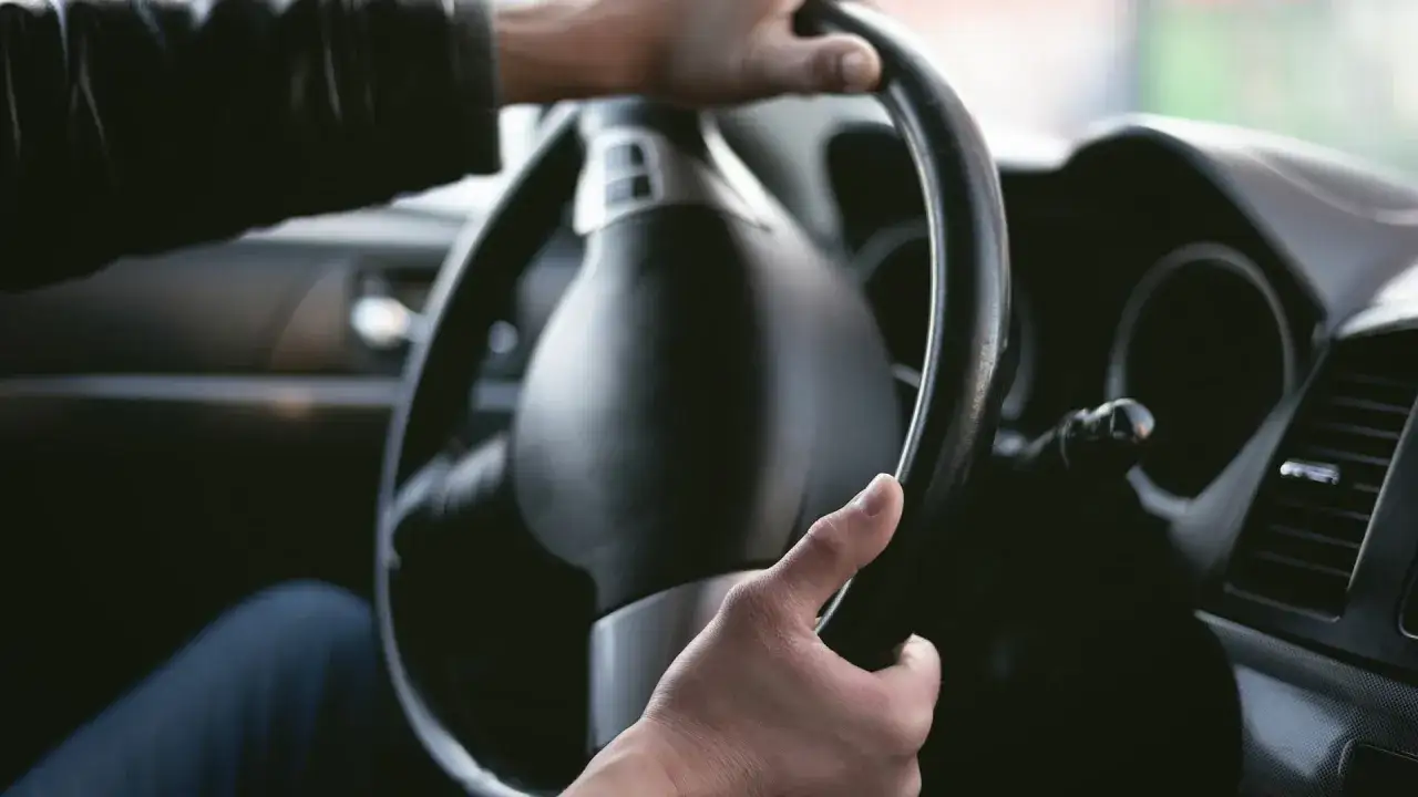 Manos al volante, sintiendo un leve ruido al girar el volante a baja velocidad.