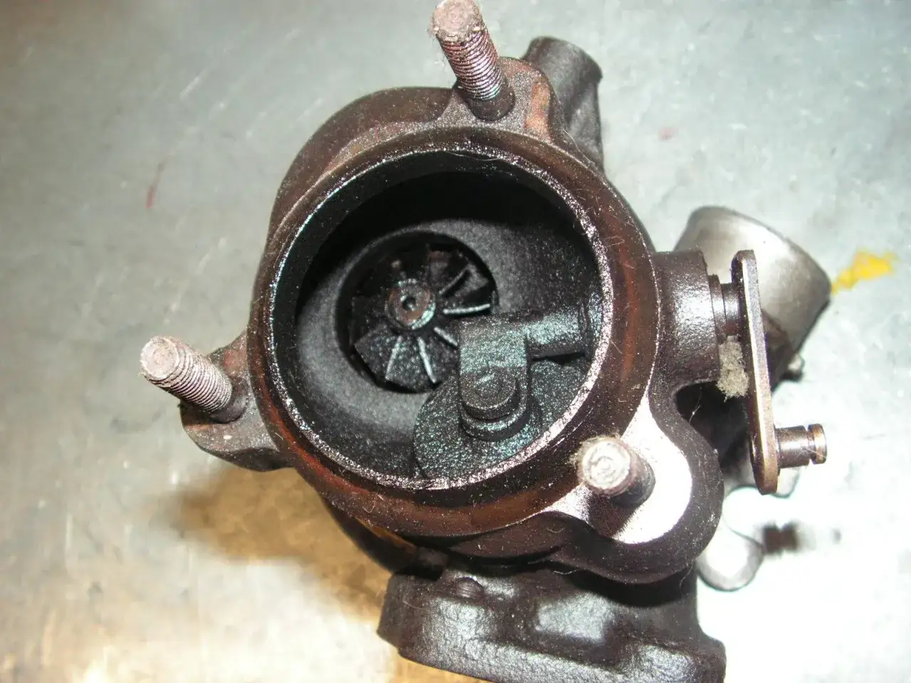 Turbocharger con signos de perdida de aceite por el turbo. Se aprecian depósitos oscuros en el interior.