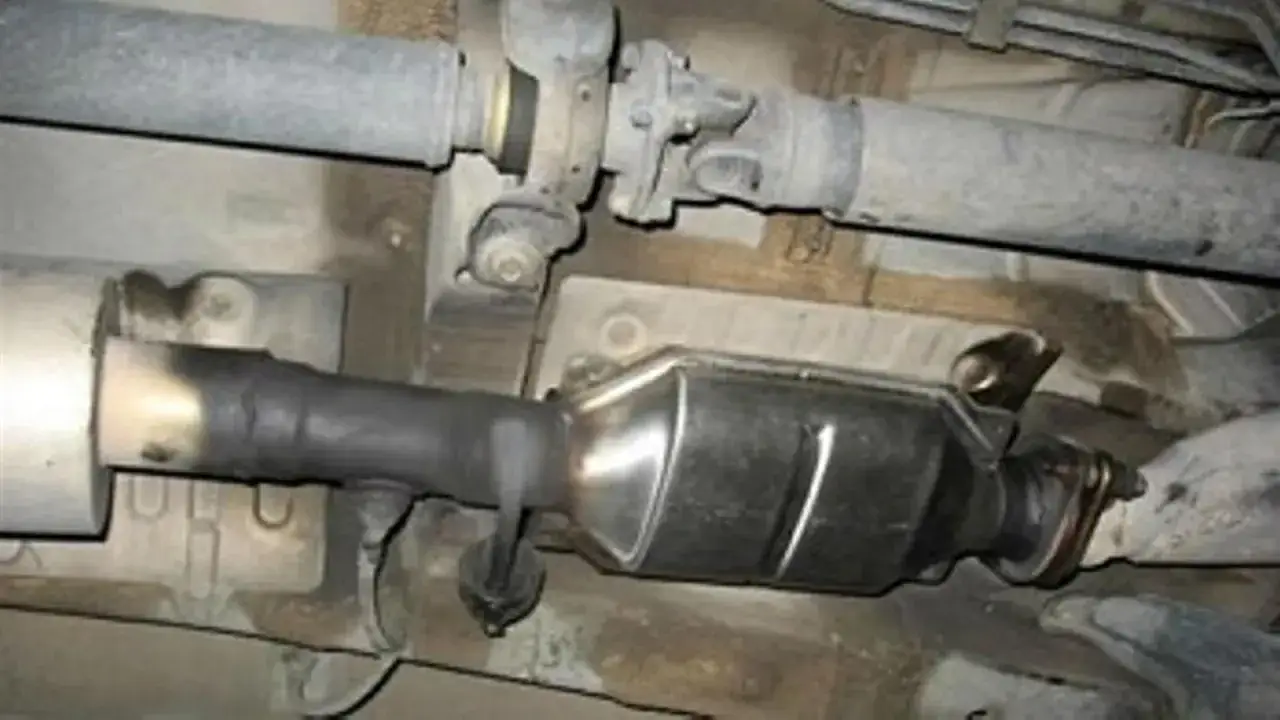Sistema de escape de Renault con posible código DTC P0420. Se observa hollín en el tubo de conexión al catalizador.