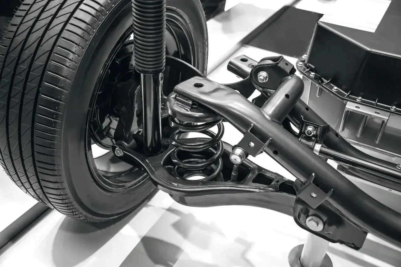Detalle de la rueda y el sistema de suspensión de un coche, mostrando el amortiguador y el muelle. Ideal para ilustrar el proceso de cambiar suspension coche.