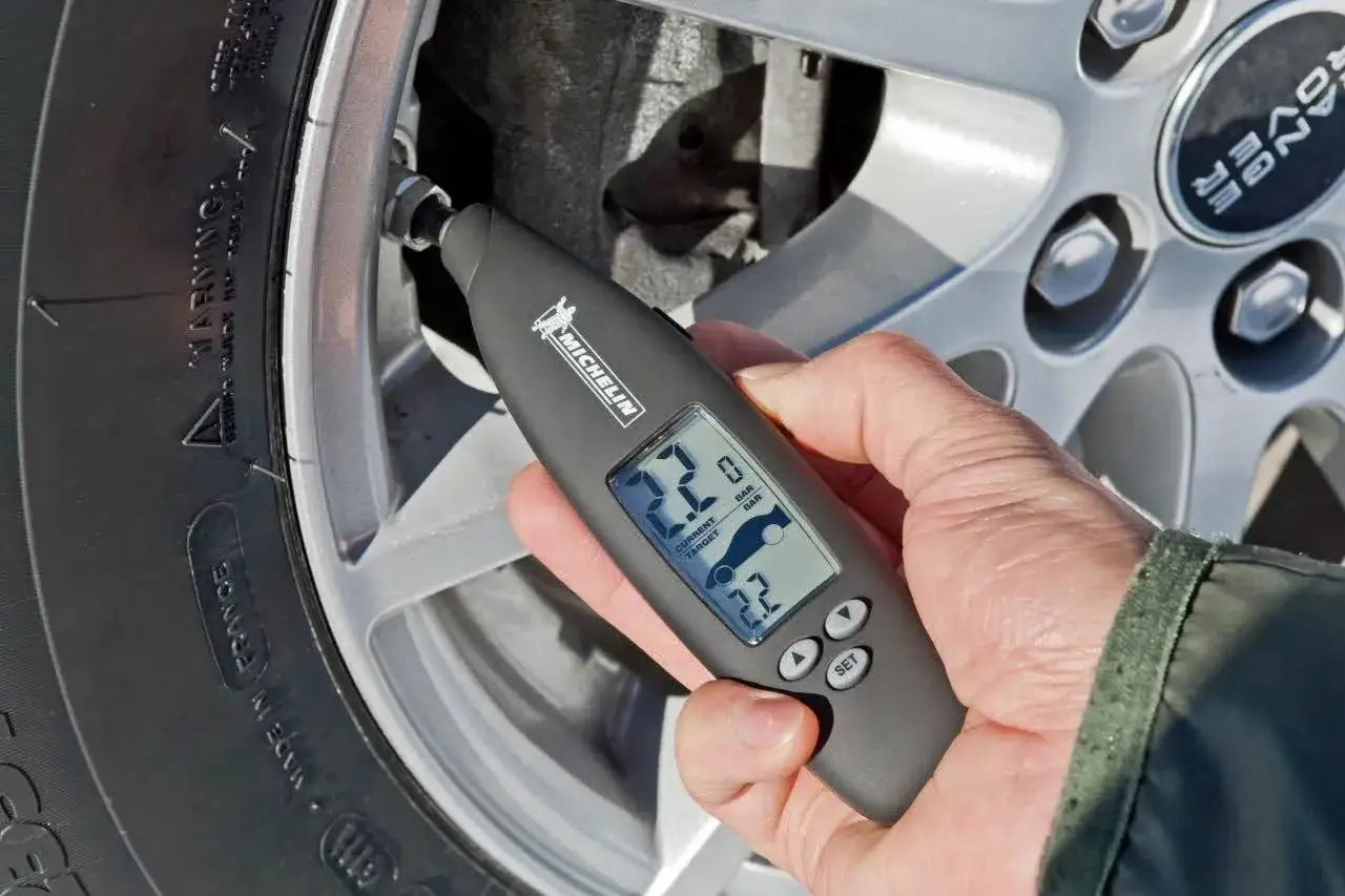 Medidor Michelin verifica la presión de inflado de neumáticos, mostrando 2.2 BAR actuales y objetivo.