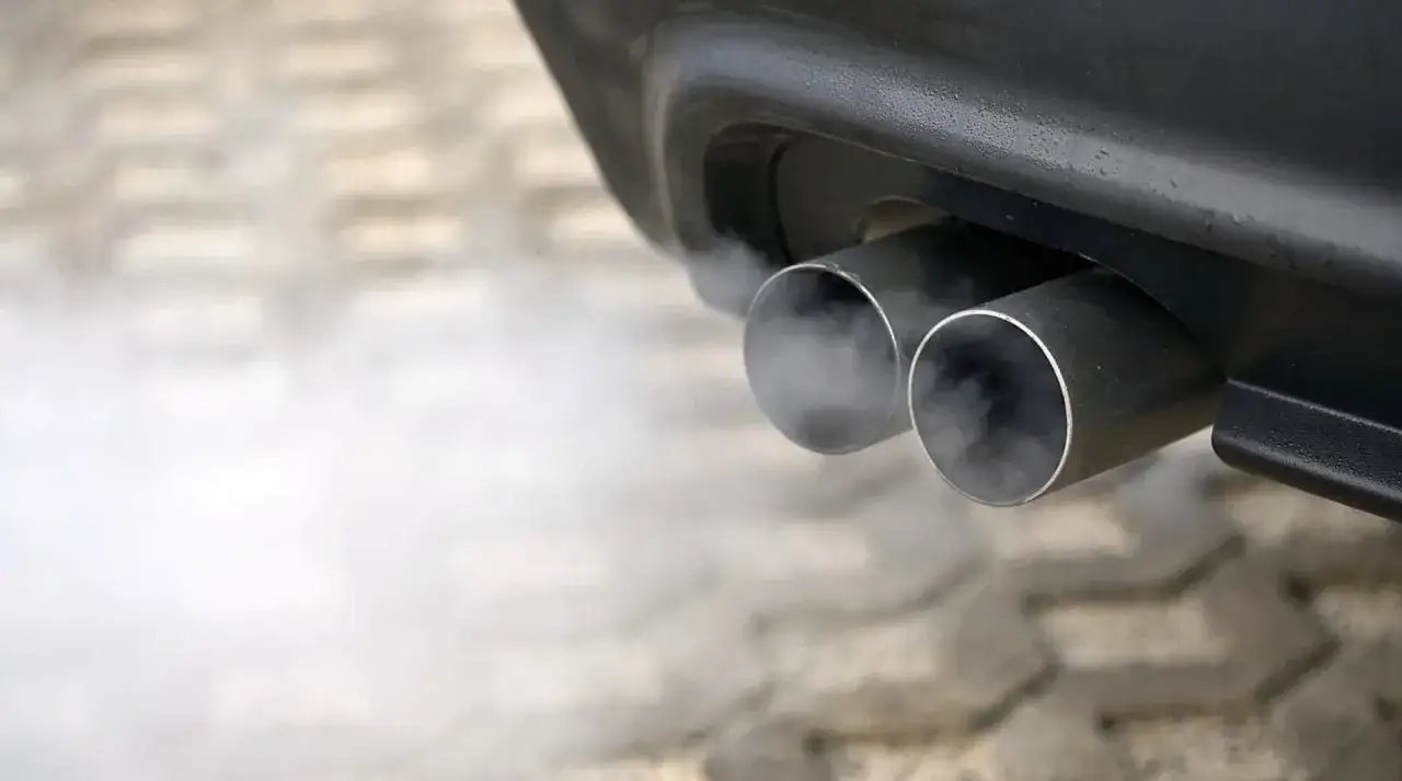 Salida de humo blanco de un tubo de escape doble, indicando posibles problemas en el motor 2.0 TDI BKD.