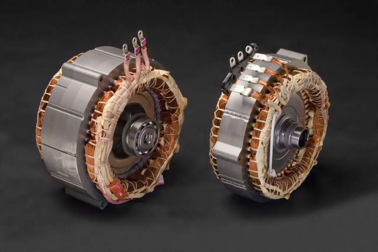 Dos motores el&eacute;ctricos con bobinados de cobre expuestos, componentes clave para un veh&iacute;culo hibrido no enchufable.
