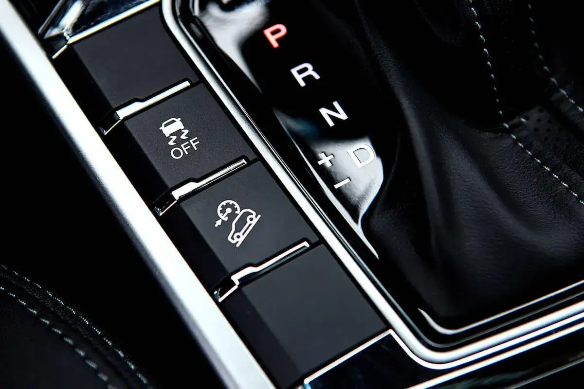 Botones del coche: control de tracción, asistente de descenso y palanca de cambios. El freno motor es una técnica de conducción.